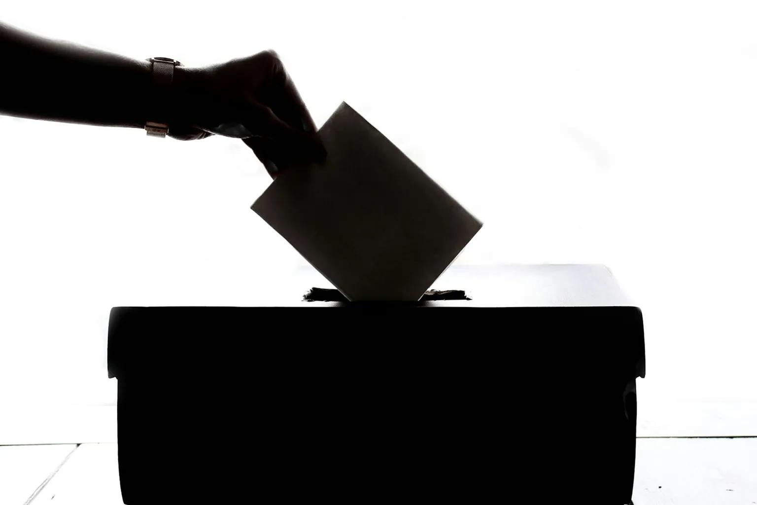 A voter casting a ballot into a ballot box